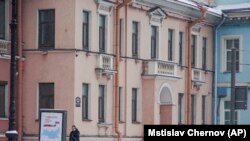 RUSSIA -- A security guard speaks on the phone outside the Concord Catering office in St. Petersburg, February 18, 2018. The company is accused of providing financing for 2016 election interference.