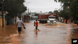 A truck makes it's way down a flooded street after heavy rain storms in Recife, Brazil, Thursday, June 26, 2014. 