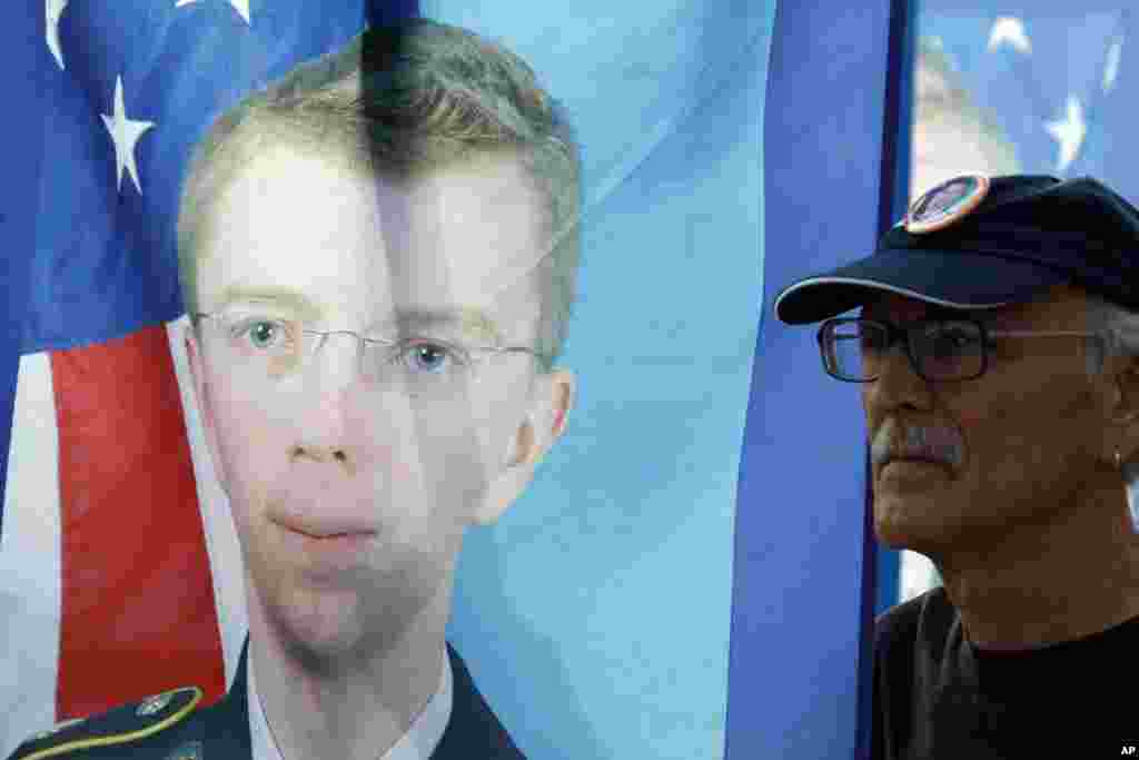 Seorang pendukung Prajurit Kelas Satu Bradley Manning memegang spanduk bergambar Manning dalam sebuah protes di luar gerbang Fort Meade, Maryland (21/8). (AP/Jose Luis Magana)