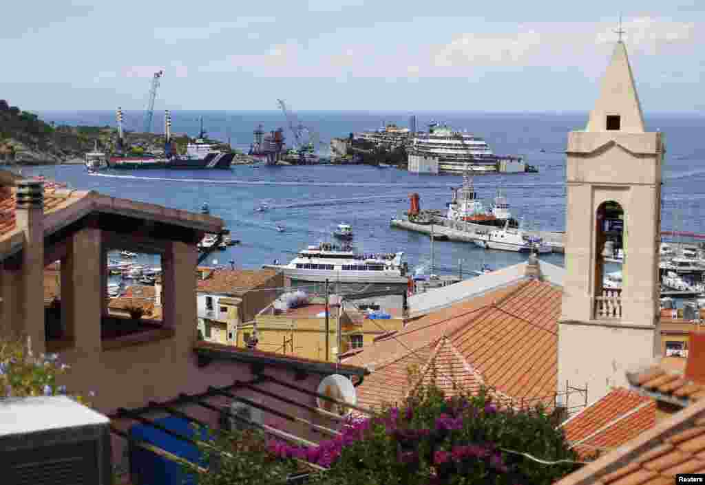 The Costa Concordia is seen over the rooftops at Giglio harbour, Giglio Island, July 13, 2014.