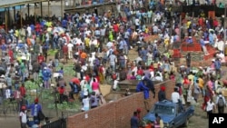 FILE: Hundreds of people buy goods at a fruit and vegetable market, despite a lockdown in an effort to curb the spread of the coronavirus, in Harare, Zimbabwe, Tuesday April 7, 2020. (AP Photo/Tsvangirayi Mukwazhi)