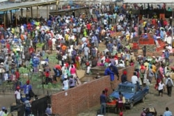 FILE: Hundreds of people buy goods at a fruit and vegetable market, despite a lockdown in an effort to curb the spread of the coronavirus, in Harare, Zimbabwe, Tuesday April 7, 2020. (AP Photo/Tsvangirayi Mukwazhi)