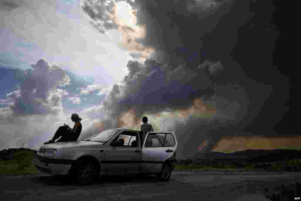 Some people watch the columns of smoke rising from a wildfire in Gois, Coimbra district, Portugal.