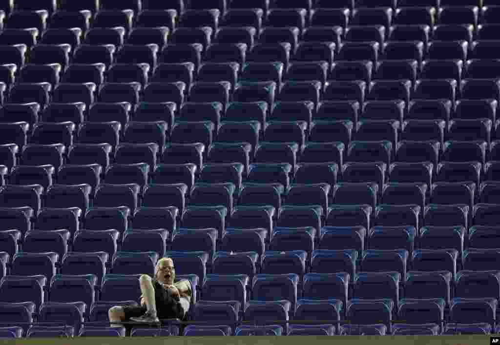 A fan yawns as he watches the match between Kei Nishikori of Japan, and Milos Raonic of Canada, during the fourth round of the 2014 U.S. Open tennis tournament in New York.