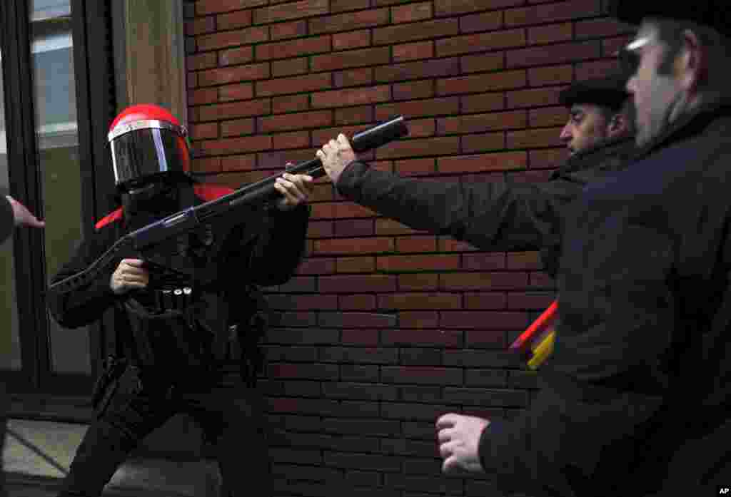 People clash with riot police during a demonstration to demand jobs for the unemployed, against government austerity measures and alleged corruption of Spanish politicians in front the regional Parliament, in Pamplona, northern Spain. 