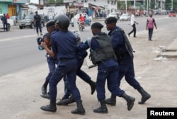 FILE - Policemen detain a protester after the Sunday Mass prayer in front of Notre Dame Cathedral in Kinshasa, Democratic Republic of Congo, Feb. 25, 2018.