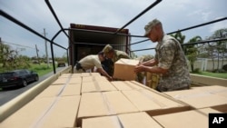 FILE - Soldiers and National Guard members organize aid in the aftermath of Hurricane Maria in Guayama, Puerto Rico, Oct. 5, 2017. 