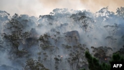 In this file photo, smoke and flames from a "back burn" are shown. The method aims to secure residential areas from encroaching bushfires, at the Spencer area in Central Coast, about 110 kilometers north of Sydney, Australia, on December 9, 2019. (Photo by SAEED KHAN /AFP)