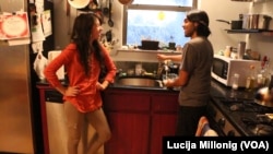 University of New Mexico international student Jose Miguel Ayala Salas cleans his kitchen with his girlfriend Araceli.