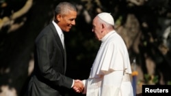 U.S. President Barack Obama, left, greets Pope Francis upon his arrival at the White House in Washington, Sept. 23, 2015. 