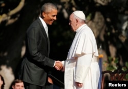 U.S. President Barack Obama, left, greets Pope Francis upon his arrival at the White House in Washington, Sept. 23, 2015.