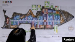 A visitor looks at an Expo map inside the Expo 2015 work site near Milan, Italy, April 27, 2015.