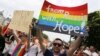 FILE - A group of Russian gays, seeking asylum in Germany because of their sexual orientation, take part in the annual Christopher Street Day gay parade in Cologne, Germany, July 5, 2015.