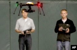 FILE - Students at John D. Odegard School of Aerospace Sciences at the University of North Dakota in Grand Forks, North Dakota, remotely pilot a drone during a demonstration, in a June 24, 2014, photo.