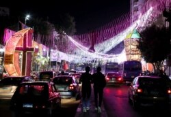 Orang-orang berjalan di jalan melewati kios toko dengan lentera Ramadhan tradisional, yang disebut "fanous", menjelang bulan suci Ramadhan, di tengah pandemi COVID-19 di Kairo, Mesir, 8 April 2021. (Foto: REUTERS/Mohamed Abd El Ghany)