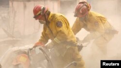 Petugas mencari korban di antara puing-puing rumah yang terbakar di Paradise, California (13/11).