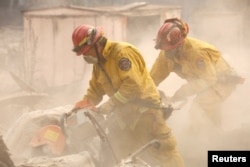 Cal Fire firefighters comb through a house destroyed by the Camp Fire in Paradise, California, U.S., Nov. 13, 2018.