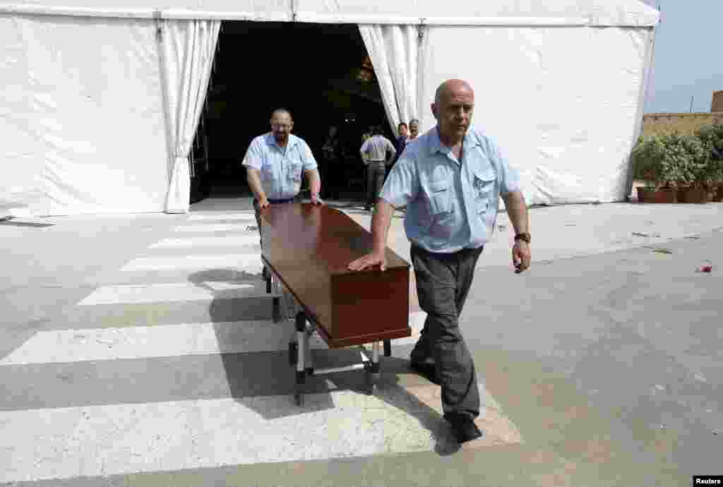 Hospital workers take a coffin with the body of a migrant to a hearse after an interfaith burial service for some of the 900 migrants who died in one of the worst disasters at sea, at Mater Dei Hospital in Tal-Qroqq, outside Valletta, April 23, 2015.