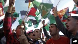 People wave Palestinians flags during celebrations for their successful bid to win U.N. statehood recognition in the West Bank city of Ramallah, Dec. 2, 2012.