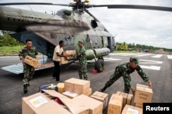 FILE - Indonesian soldiers along with a local resident unload food and medical aid in Ewer, Asmat District, in the remote region of Papua, Indonesia, Jan. 29, 2018 in this photo taken by Antara Foto.