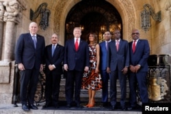 U.S. President Donald Trump and first lady Melania Trump pose with Saint Lucia Prime Minister Allen Chastanet (L), Dominican Republic President Danilo Medina (2ndL), Jamaica's Prime Minister Andrew Holness (3rdR), Haiti's President Jovenel Moise (2ndR), Bahamas Prime Minister Hubert Minnis (R) and other leaders prior to a working visit at Mar-a-Lago in Palm Beach, Florida, March 22, 2019.