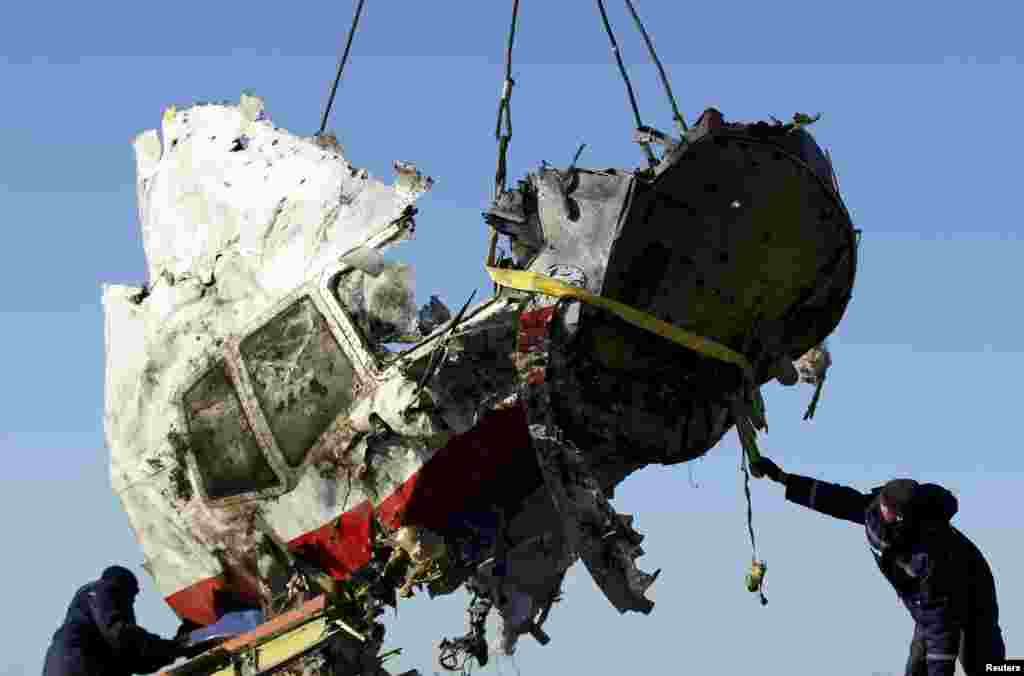 Local workers transport a piece of the Malaysia Airlines flight MH17 at the site of the plane crash near the village of Hrabove (Grabovo) in Donetsk region, eastern Ukraine.