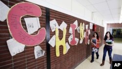 Students walk by a display about China at Stearns High School in Millinocket, Maine, in 2011. The public high school began recruiting foreign students in an effort to raise money to avoid cuts in programs, and in response to a shrinking student population