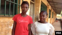 Elizabeth Issa (left) stands with a fellow student outside a school offering classes for pregnant and lactating mothers in Freetown, Sierra Leone, Feb. 22, 2016. (Photo - Nina deVries/VOA) 