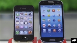 Samsung Electronics' Galaxy S III (R) and Apple's iPhone 4S are displayed at a mobile phone shop in Seoul, South Korea, August 24, 2012.