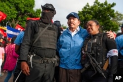 FILE - Nicaraguan police have their picture taken with President Daniel Ortega, in Masaya, Nicaragua, July 13, 2018.