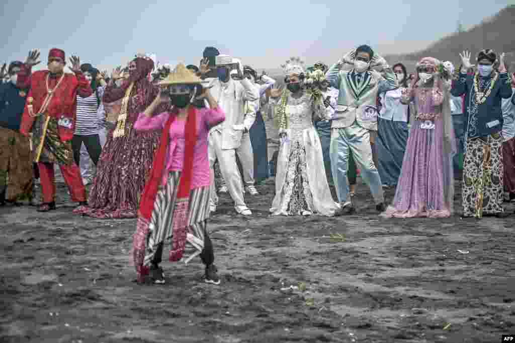 Brides and grooms dance during a mass wedding of 75 couples at a field in Bantul, Yogyakarta, Indonesia.