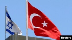 FILE - A Turkish flag flutters atop the Turkish embassy as an Israeli flag is seen nearby, in Tel Aviv, Israel, June 26, 2016.
