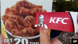 A customer holds a box of Kentucky Fried Chicken outside an KFC restaurant, Tuesday, July 13, 2010, in Mountain View, Calif. (AP Photo/Paul Sakuma)