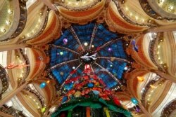 Sebuah pohon Natal raksasa berdiri di department store Galeries Lafayette tempat lampu dinyalakan untuk musim perayaan di Paris, Perancis, 30 November 2020. (Foto: Reuters)