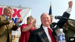 FILE - U.S. Senator Max Cleland, foreground, achnowledges the crowd at a campaign rally in Atlanta, Georgia, Aug. 21, 2002. Cleland, who lost three limbs to a Vietnam War hand grenade blast yet went on to serve as a U.S. senator, died Nov. 9, 2021. 