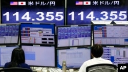 Money traders work in front of the computer terminal at a foreign exchange brokerage in Tokyo, Tuesday, Feb. 9, 2016. Asian markets tumbled Tuesday as renewed jitters about the global economy set off a wave of selling. (AP Photo/Shizuo Kambayashi)