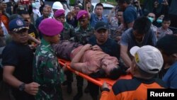 Petugas penyelamat mengevakuasi seorang korban selamat dari tambang yang ambruk di Bolaang Mongondow, Sulawesi Utara.