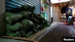 Sandbags are put in front of a shop at Lei Yue Mun, a village as one of the several areas at-risk, as Typhoon Mangkhut approaches Hong Kong, China, Sept. 14, 2018.