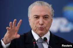 FILE - Brazil's President Michel Temer gestures during the launch of the new financing line of Bank Caixa Economica Federal Brasilia, Nov. 24, 2016.
