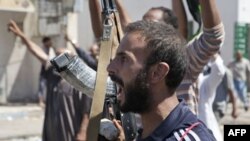 Binh sĩ của phe nổi dậy Libya ở Zawiya, phía tây Libya, ăn mừng khi nghe tin thành phố Surman, một điểm chiến lược quan trọng, hiện đã nằm dưới sự kiểm soát của các lực lượng nổi dậy, ngày 14/8/2011