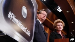 FILE - Sen. Gary Peters, D-Mich., left, and Sen. Debbie Stabenow, D-Mich., listen to a question as they discuss proposed legislation to help Flint, Michigan, with its current water crisis during a news conference on Capitol Hill in Washington, Jan. 28, 2016.