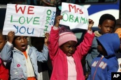 Des enfants accueillant Mme Obama au mémorial Hector Pietersen de Soweto