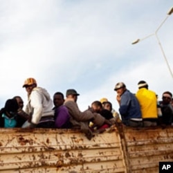 Migrant refugees atop a truck in the Libyan city of Misrata. IOM says it has evacuated some 8,500 migrants from Misrata so far, the majority during the height of the violence there.