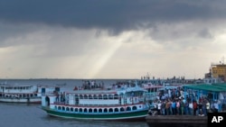 FILE - People getting on passenger ferries on the Padma River in the Munshiganj district, Bangladesh, Aug. 4, 2014.