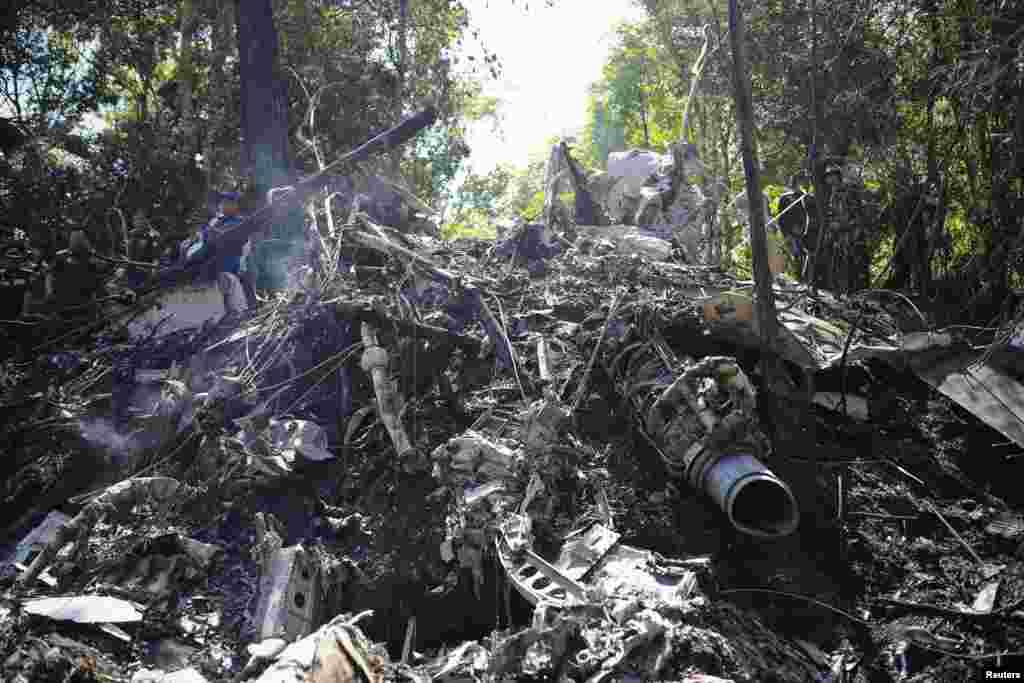 Rescue workers search an air force plane crash site near Nadee village, Xiang Khouang province, Laos, May 17, 2014.