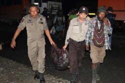 Anggota kepolisian mengevakuasi warga setelah baku tembak antara pasukan keamanan dan kelompok separatis di Mimika, Papua, 8 Maret 2020. (Foto: Sevianto Pakiding/Antara via Reuters)