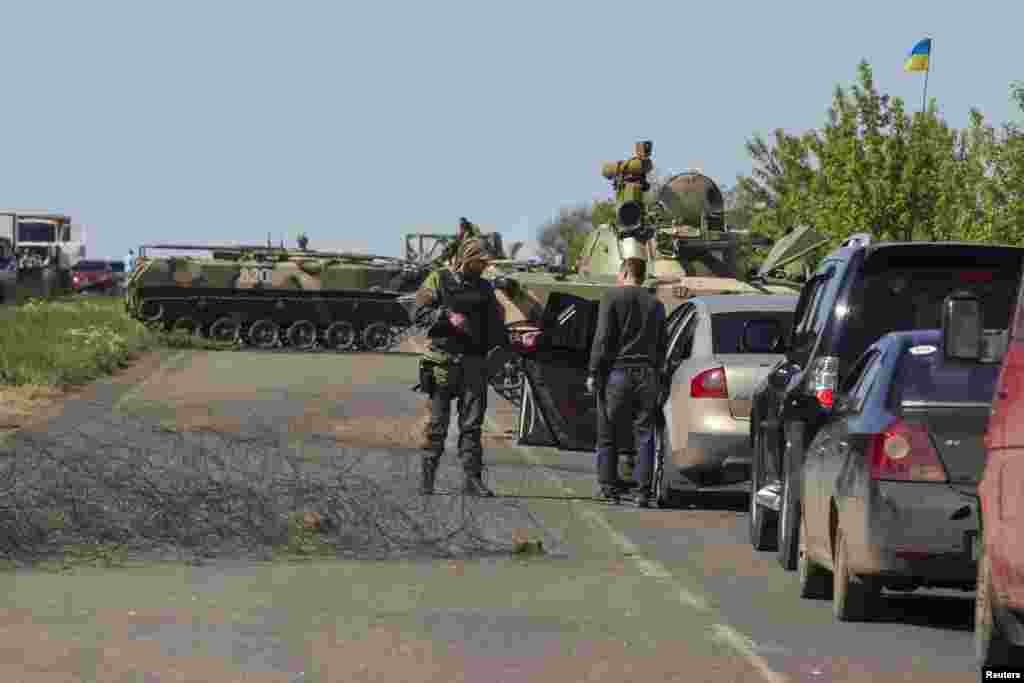 A Ukrainian soldier talks to a man at a checkpoint near the town of Slovyansk, May 7, 2014.