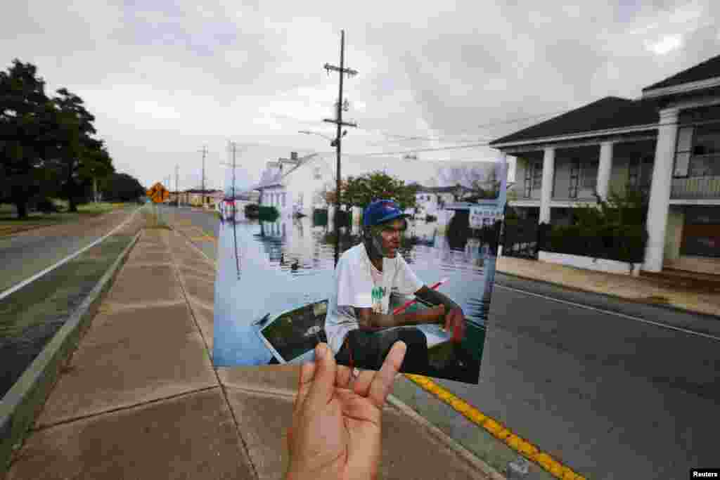 Fotografer Carlos Barria memegang foto yang ia ambil tahun 2005 setelah serangan Badai Katrina, memasangkannya dengan lokasi yang sama 10 tahun kemudian, di New Orleans, Louisiana (16/8). ​(Reuters/Carlos Barria TPX)