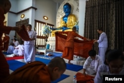 Biksu wanita Thailand dan biksu wanita Buddha atau Bhikkhuni melipat jubah safron mereka selama sesi latihan menjelang penahbisan mereka menjadi biksu pemula di biara Songdhammakalyani, provinsi Nakhon Pathom, Thailand, 4 Desember 2018. (Foto: Reuters)