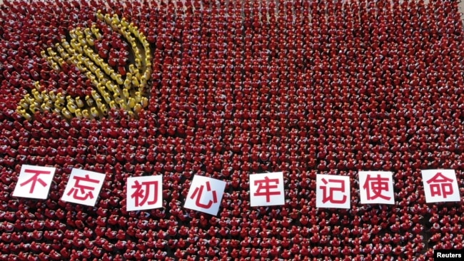 中国浙江省金华市的中共党员手举“不忘初心牢记使命”的标语牌组成中国党旗图案的阵仗。(2019年6月28日)
